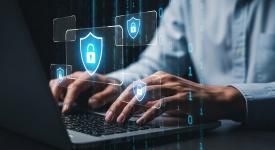 hands typing on computer with security lock floating